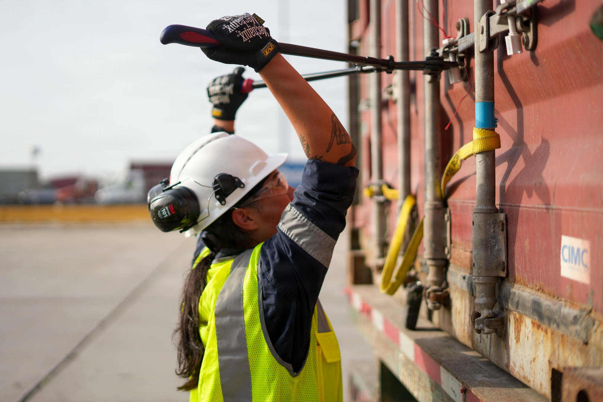 A container inspector works at the locking bars of a freight container at Barbours Cut Container Terminal.